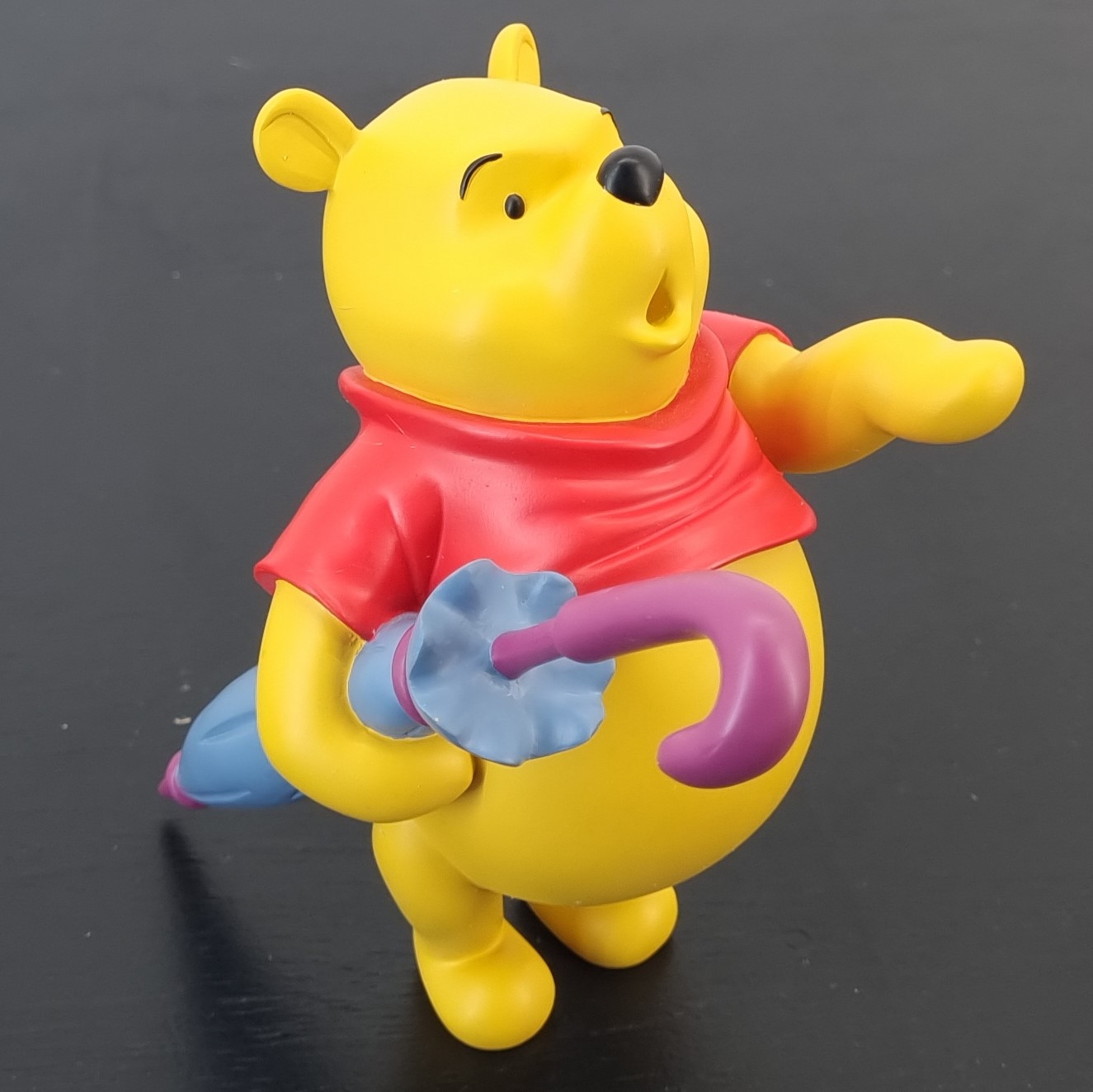 winnie the pooh holding a umbrella statue